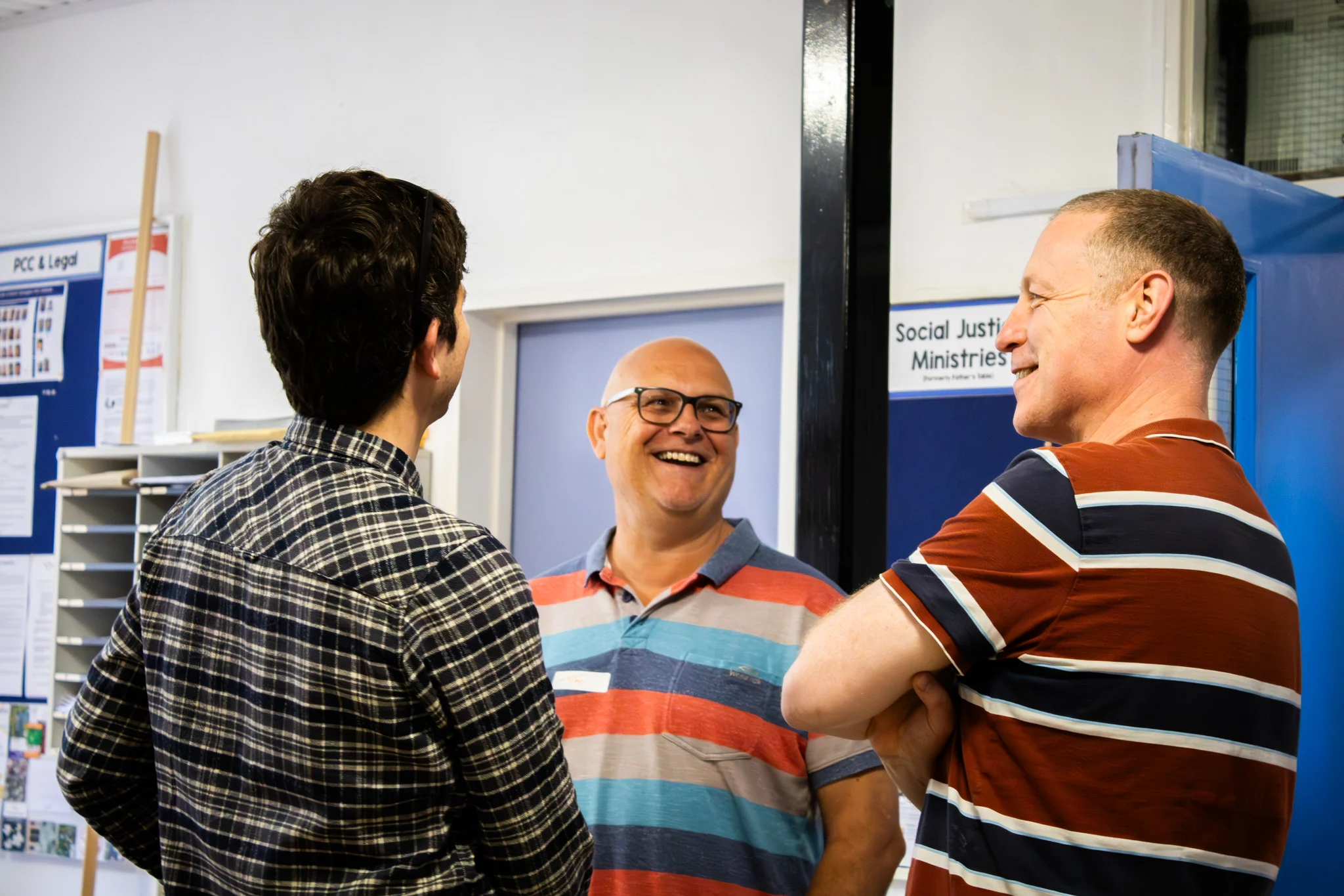Men chatting and laughing in the church foyer